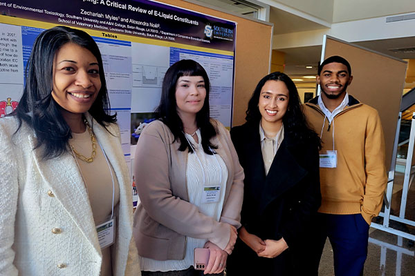 faculty and students with poster